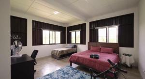a bedroom with a bed and a couch and windows at DuriDuri Eco Resort in Bentong