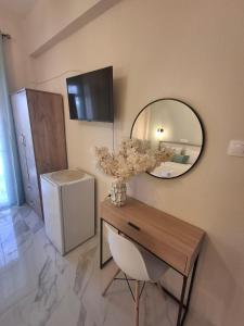 a room with a table with a mirror and a chair at Foteini Rooms in Skala Sotiros
