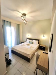 a bedroom with a large bed and a table and a desk at Foteini Rooms in Skala Sotiros +9 photos