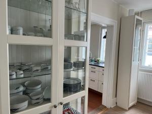 a kitchen with a glass cabinet filled with dishes at Ribe Sønderport Bed & Kitchen in Ribe +20 photos