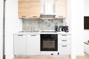 a white kitchen with a sink and a stove at Seven Thousand Apartment in Brescia