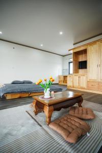 a living room with a coffee table and a bed at Khách Sạn Vân Nguyên in Buôn Ea Yông