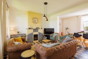 a living room with two couches and a fireplace at Huisje aan de Schelde in Spiere