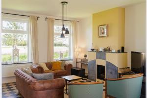 a living room with a couch and a fireplace at Huisje aan de Schelde in Spiere