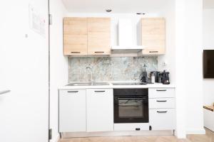 a white kitchen with a sink and a stove at Seven Thousand Apartment in Brescia +38 photos