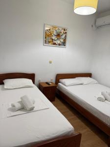 two beds in a room with a picture on the wall at Guesthouse Mili in Piqeras