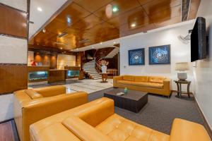 a living room with orange couches and a tv at Hotel Aura - 05 Mins from New Delhi Railway Station & Connaught Place in New Delhi