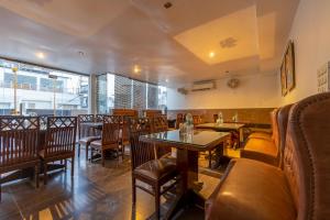 a restaurant with wooden chairs and tables and tablesktop at Hotel Aura - 05 Mins from New Delhi Railway Station & Connaught Place in New Delhi