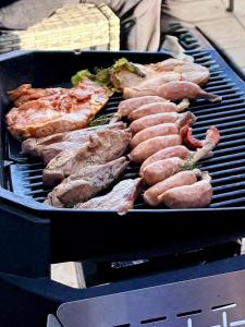 a grill with sausage and meat on it at Cielito Hayama 最大10名 海まで10分 テラスBBQ 葉山の空と海と富士山に出会うヴィラ in Hayama