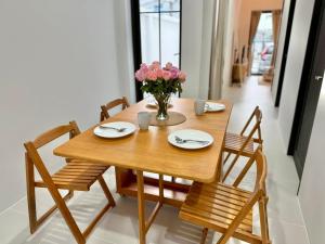 a wooden table with two chairs and a vase of flowers at La Casa Bella in Ban Nong Chaeng