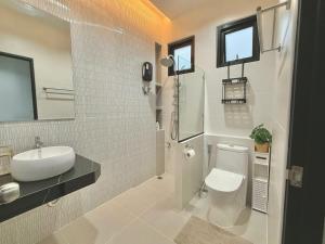a white bathroom with a sink and a toilet at La Casa Bella in Ban Nong Chaeng +12 photos