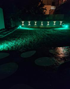 an empty driveway at night with green lights at Foteini Rooms in Skala Sotiros