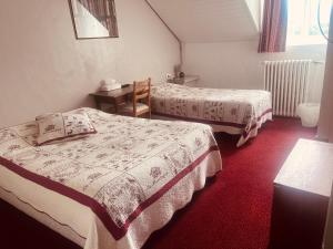 a hotel room with two beds and a table at Hôtel du Centre in Villard-de-Lans +10 photos