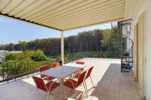 a patio with a table and chairs on a balcony at Seaside House in Paestum