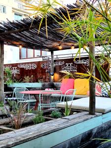 a patio with tables and chairs and a pergola at Sud Hôtel Restaurant in Bastia