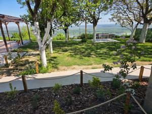 a garden with a path and trees and a fence at Casa Horizont in Slankamenački Vinogradi