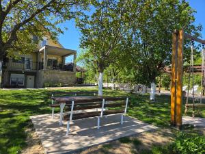 a picnic table and bench in front of a house at Casa Horizont in Slankamenački Vinogradi