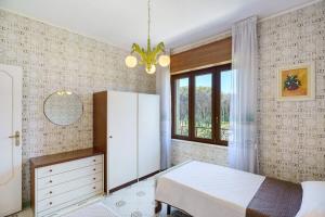 a bedroom with a bed and a dresser and a window at Seaside House in Paestum +23 photos