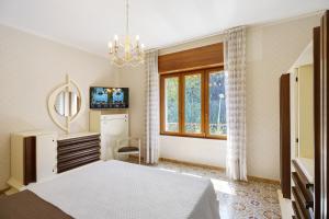 a bedroom with a bed and a tv and a window at Seaside House in Paestum