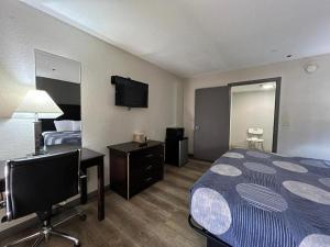 a hotel room with a bed and a flat screen tv at Speedway Inn & Suites in Griffin +40 photos