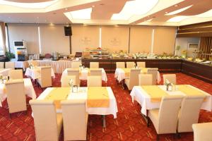 a restaurant with white tables and chairs and a buffet at My House Hotel in Samsun