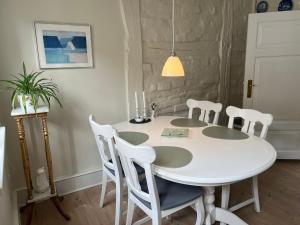 a white dining room table with white chairs and a table at Ribe Sønderport Bed & Kitchen in Ribe