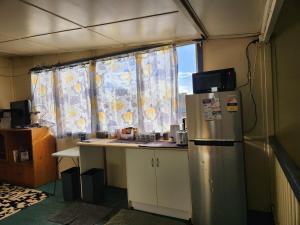 a kitchen with a refrigerator and a window at Hotel Cecil Wondai in Wondai