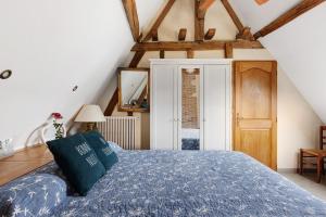 a bedroom with a bed with a blue comforter at Gîte Roses De Loire in Bréhémont
