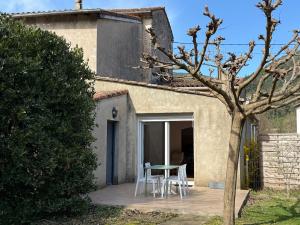 a patio with a table and chairs in front of a house at Ma maisonnette en Cévennes in Le Vigan