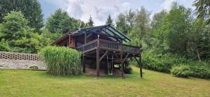 a tree house with a deck in a yard at Seewaldhüttn in Oberaichwald