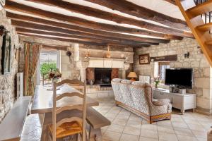 a living room with a couch and a television at Gîte Roses De Loire in Bréhémont