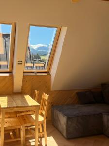 a room with a table and a bed and a window at Apartamenty pod Tatrami in Zakopane