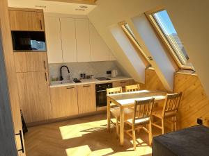 a kitchen with a table and chairs in a room at Apartamenty pod Tatrami in Zakopane