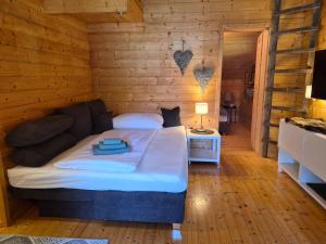 a bedroom with a bed in a wooden room at Seewaldhüttn in Oberaichwald