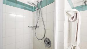 a shower in a white tiled bathroom at Residence Capobianco in Portoferraio +92 photos