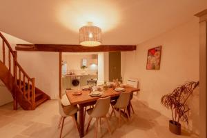 a dining room with a wooden table and chairs at Maison POHESY in Figeac