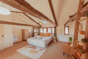 a bedroom with a white bed and a chair at Maison POHESY in Figeac