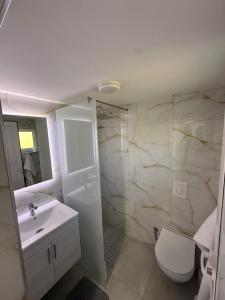 a white bathroom with a sink and a toilet at Panorama Helshan Hotel in Helshan