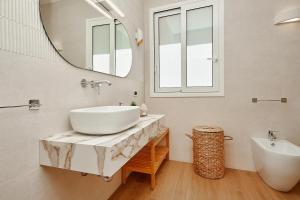 a white bathroom with a sink and a mirror at Villa Gabbiano - Scopello-Villas in Scopello +44 photos