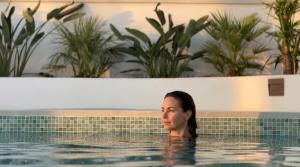 a woman is sitting in a swimming pool at Villa Kahuna Sotogrande in Sotogrande