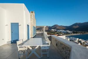 a table and chairs on a balcony overlooking the water at Kaerati Apartments in Katapola +39 photos