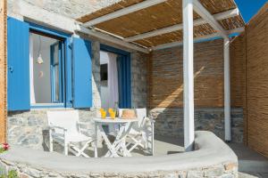 a patio with a table and chairs under a pergola at Kaerati Apartments in Katapola