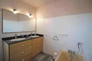 a bathroom with two sinks and a mirror and a tub at La maison d'eugénie in Jourgnac +34 photos