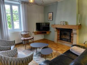 a living room with a couch and a fireplace at La maison d'eugénie in Jourgnac