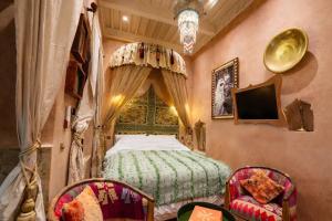 a bedroom with a bed and two chairs at Riad Rafeef in Essaouira