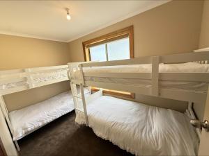 two bunk beds in a room with a window at B & B on Yorkes in Edithburgh