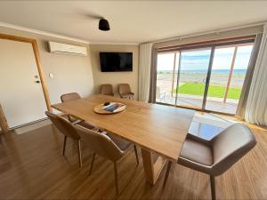 a dining room with a wooden table and chairs at B & B on Yorkes in Edithburgh