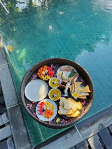 a tray of food sitting next to a swimming pool at Villa Hillcrest Weligama in Weligama