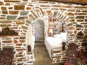 a bedroom with a bed in a stone wall at Seafront House, Private Beach, Sunset View, Diliso in Vathírrevma +39 photos