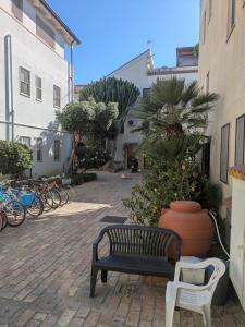 a bench and a chair in a courtyard with bikes at SeaYouSoverato Apartment in Soverato Marina